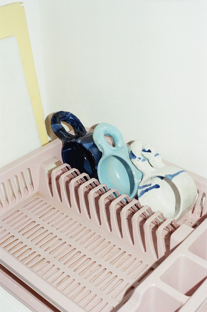 Handmade ceramic pieces from the NIKO JUNE Studio Series arranged on a drying rack.