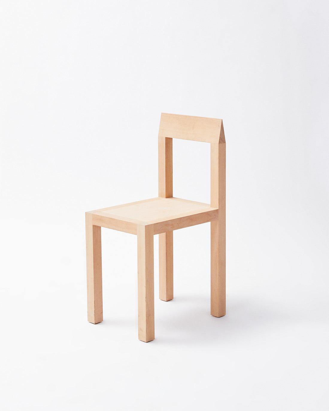 Handmade in denmark chair in slanted view on white background