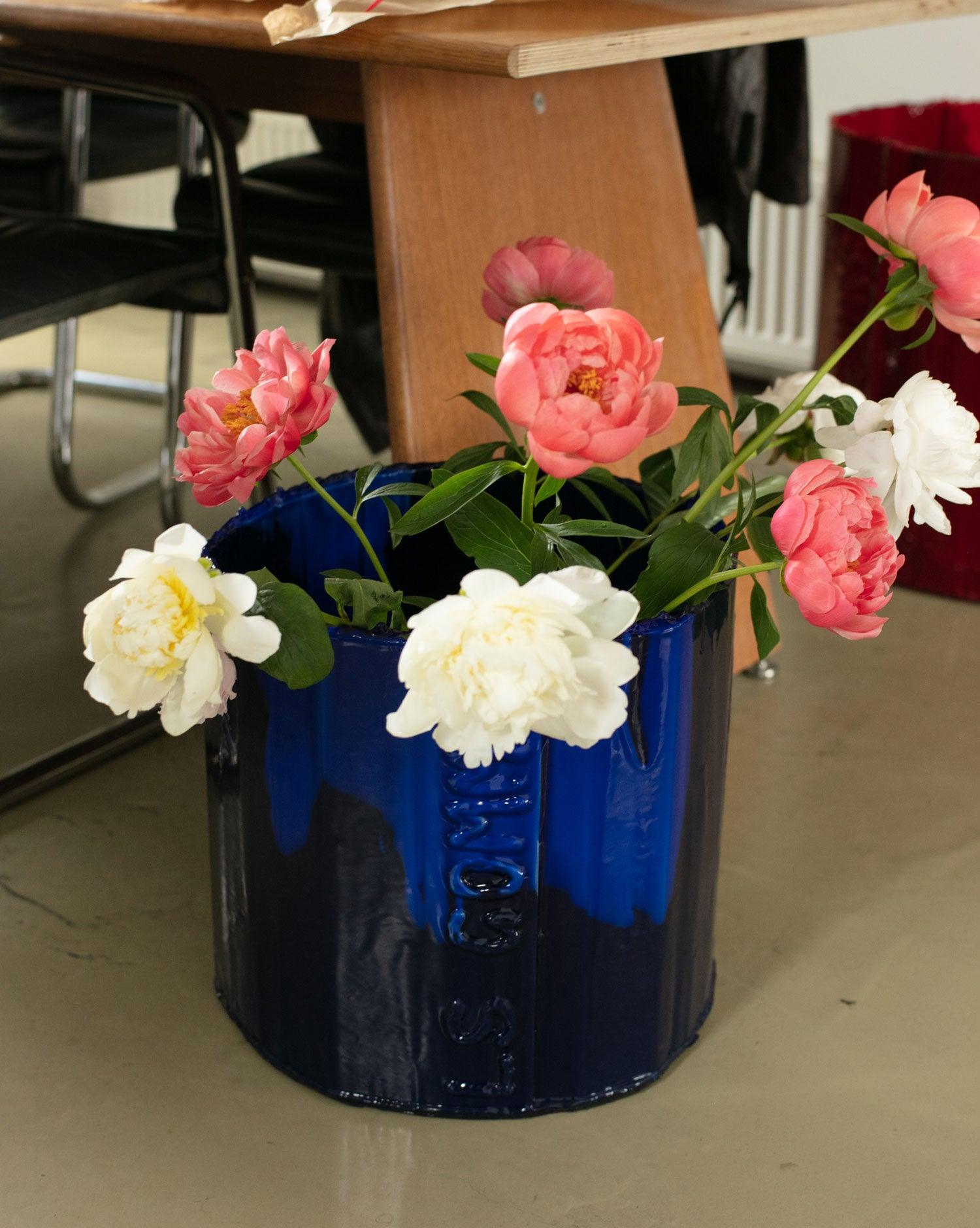 Handmade organizer object Deep Flex blue with white and pioneer flower on an office floor