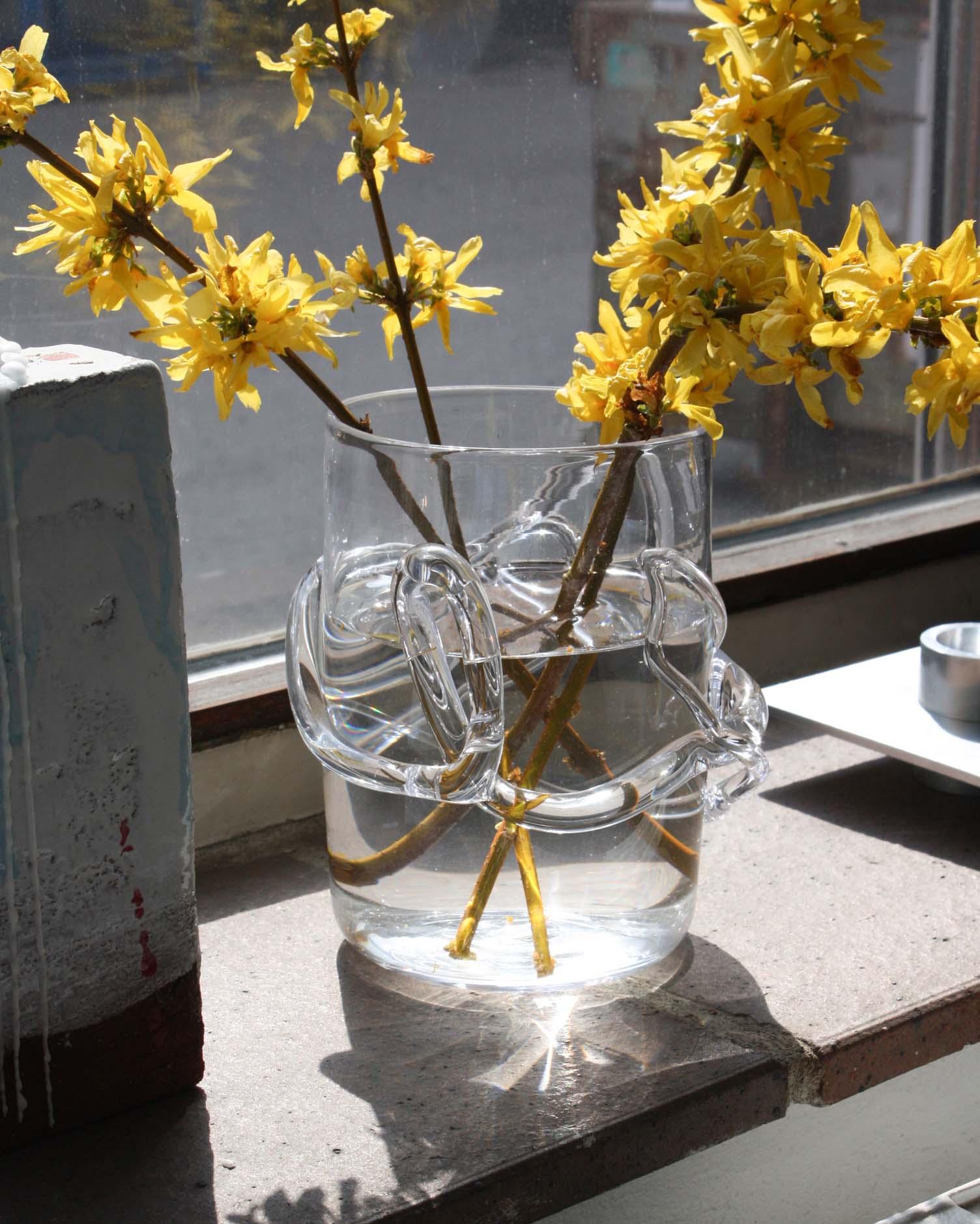 Melted glass vase with water melted glass design with flowers placed in the sun