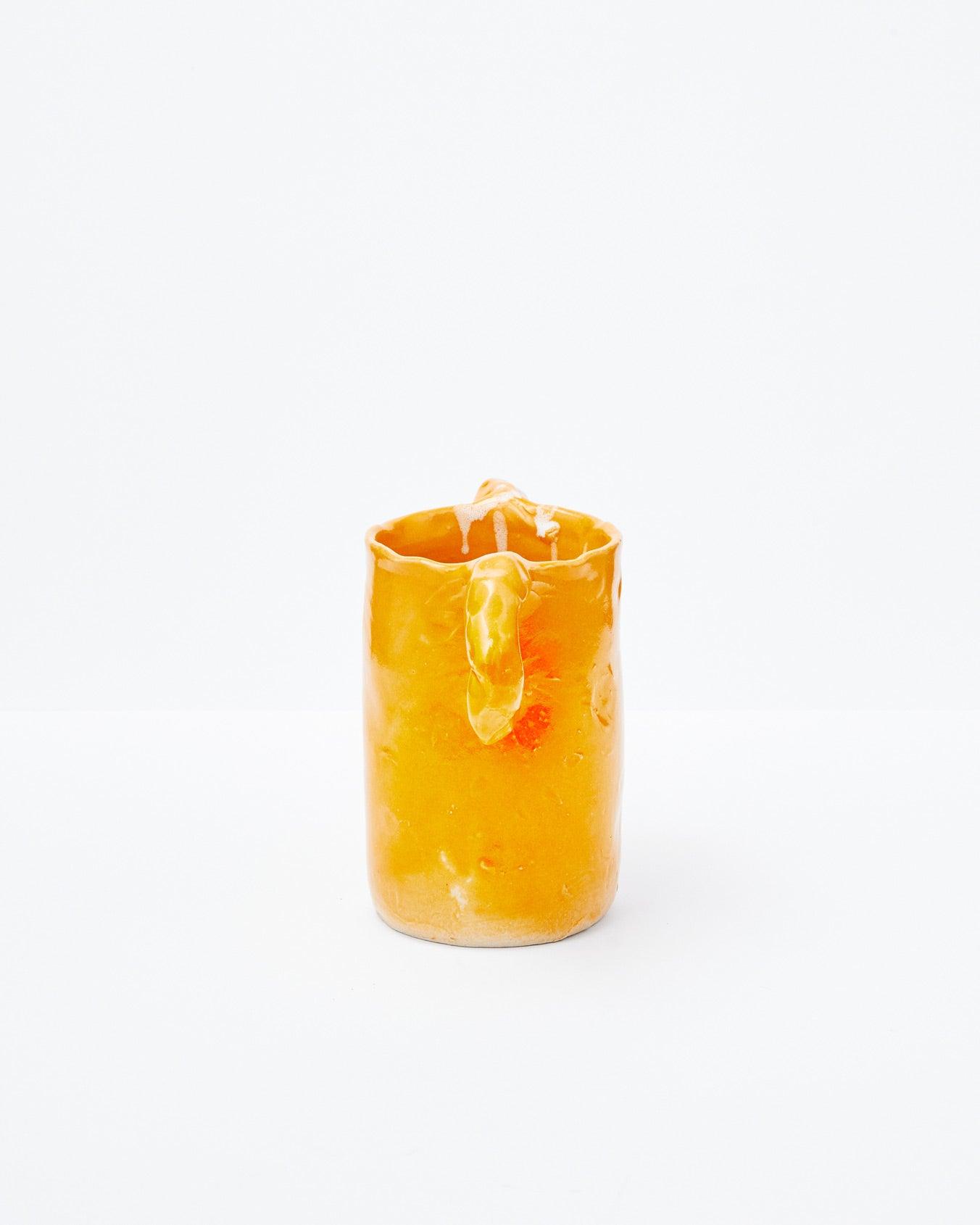 Orange modern ceramic vase with two handles in an upright position on a white background